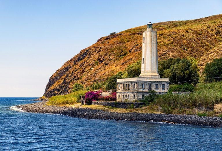 Il faro di Vulcano sul promontorio verde affacciato sul mare